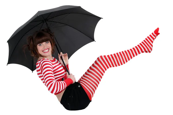 Mujer joven con ropa a rayas sosteniendo un paraguas — Foto de Stock