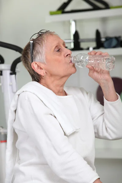 Kobieta w siłowni wody pitnej — Zdjęcie stockowe
