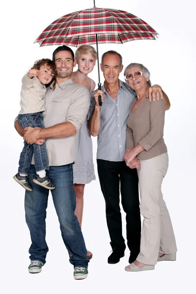 Familie beschermd onder een paraplu, studio opname — Stockfoto