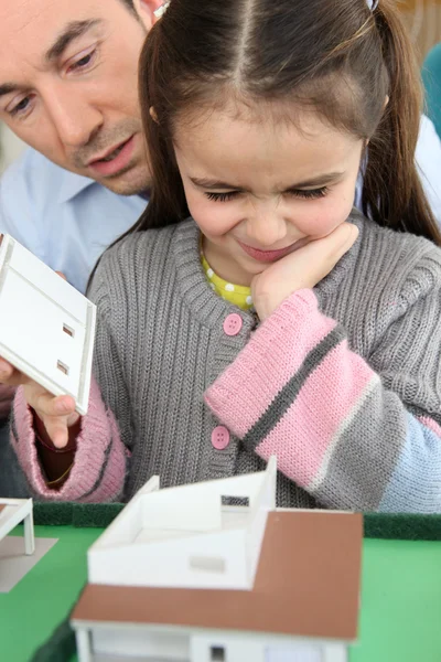 Pai e filha olhando para um modelo de casa — Fotografia de Stock