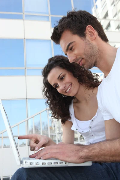 Couple with glass building in front of computer — Stock Photo, Image