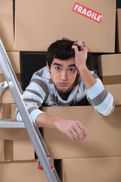 Homem cercado por caixas de papelão — Fotografia de Stock