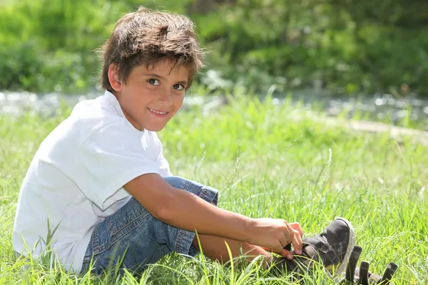 Kind zit in een veld — Stockfoto