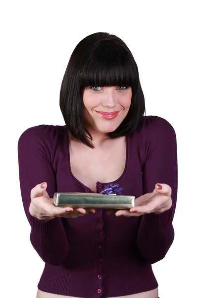 Mujer con sonrisa juguetona mostrando regalo — Foto de Stock