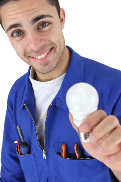 Šťastné elektrikář v kombinéze drží žárovku — Stock fotografie