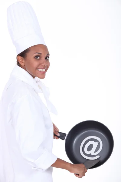Chef sosteniendo sartén con en símbolo —  Fotos de Stock