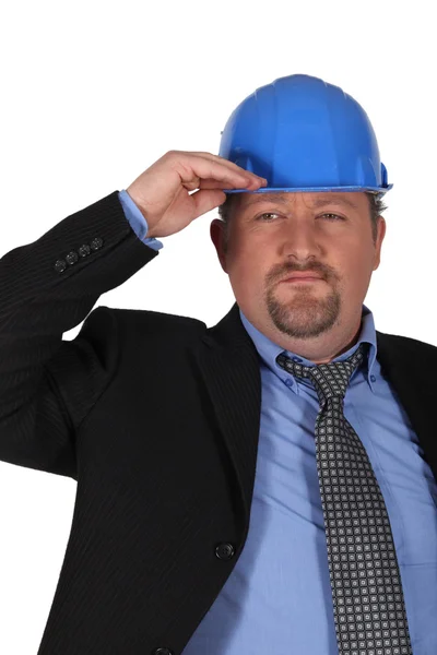Businessman in a hardhat saluting — Stock Photo, Image