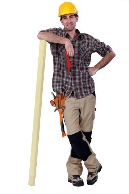 Carpenter leaning against a wooden plank clipart