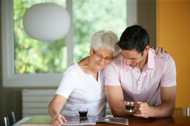 Senior woman drinking coffee with her son clipart