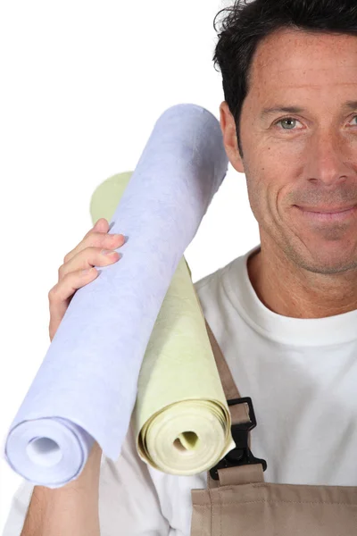 Hombre llevando rollos de papel pintado — Foto de Stock
