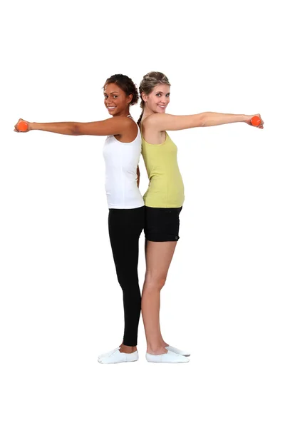 Two women doing exercises with dumbbells — Zdjęcie stockowe