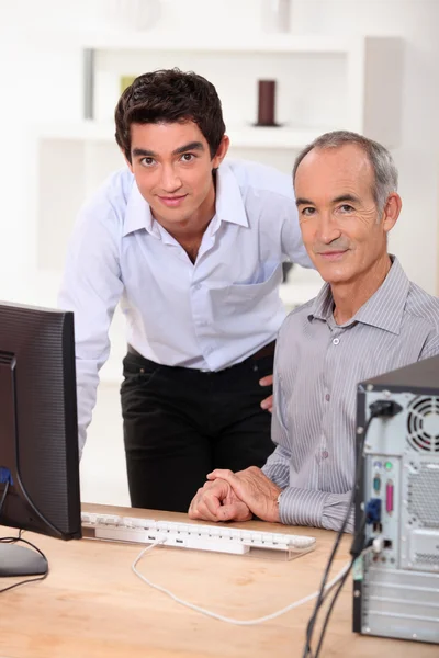Jóvenes enseñando informática a personas mayores — Foto de Stock