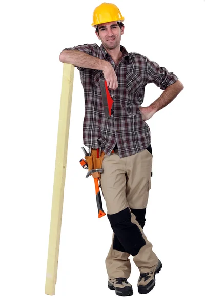 Carpenter leaning against a wooden plank — Stock Photo, Image