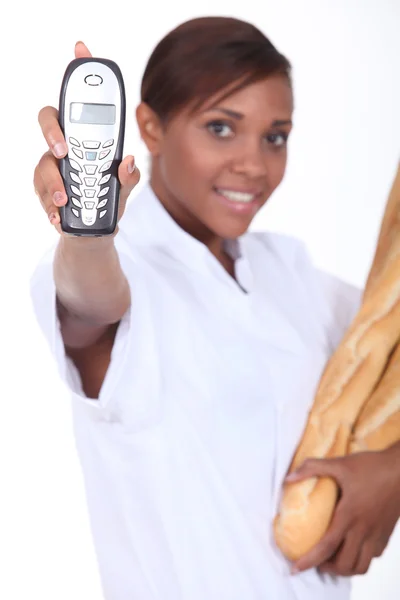 Panadero joven mostrando teléfono —  Fotos de Stock