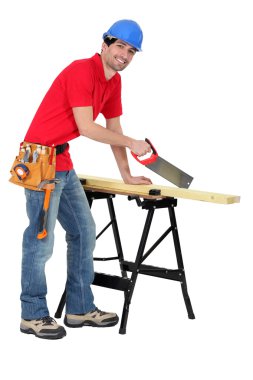 Carpenter sawing a piece of wood clipart
