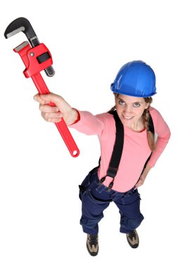 Tradeswoman holding up a pipe wrench clipart