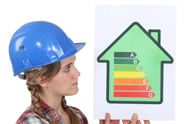 Mujer constructora de viviendas con un signo de calificación energética — Foto de Stock