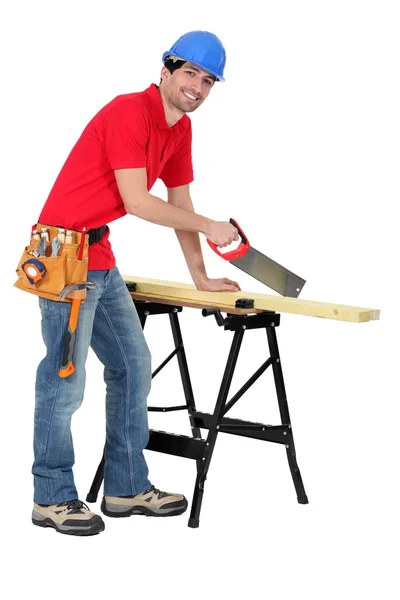 Carpinteiro serrar um pedaço de madeira — Fotografia de Stock