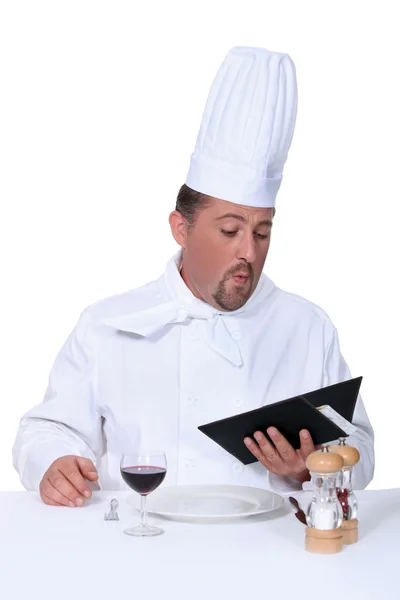 Chef choosing food from his own menu — Stock Photo, Image
