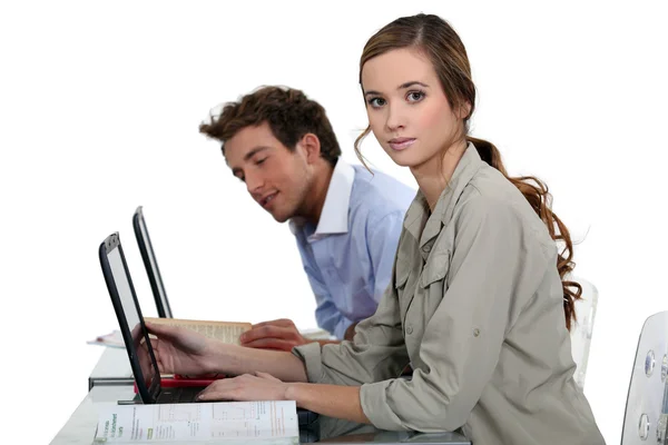 Dizüstü bilgisayarlar önünde bir masada oturan kız ve erkek — Stok fotoğraf