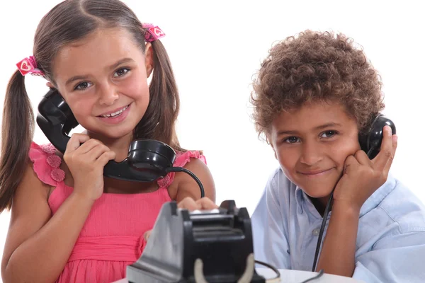 Due bambini che usano un vecchio telefono — Foto Stock