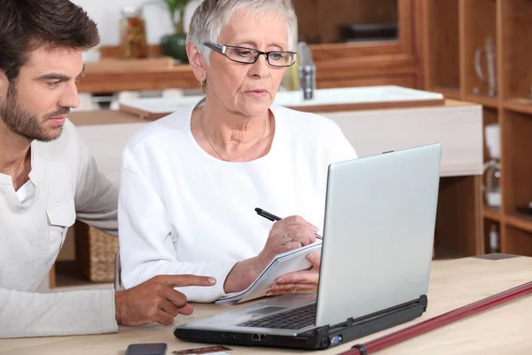 Uomo e donna anziana di fronte al computer portatile — Foto Stock