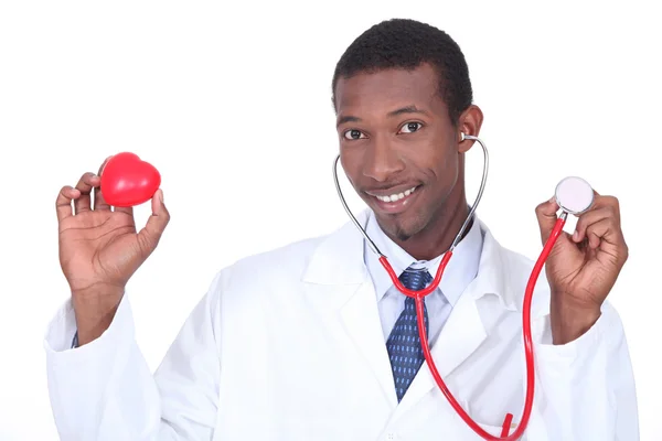 Доктор держит стетоскоп и пластиковое сердце — стоковое фото