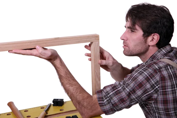 Joiner inspecionando moldura de madeira — Fotografia de Stock