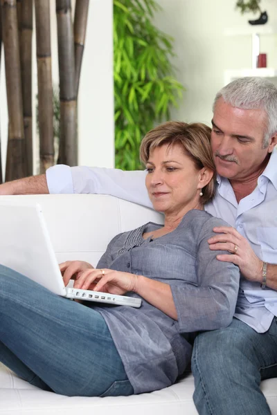 Äldre par embracing på soffan — Stockfoto
