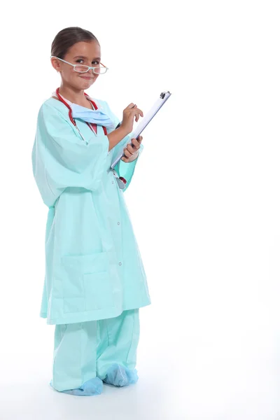 Kind in een artsen schrobt met stethoscoop en Klembord — Stockfoto