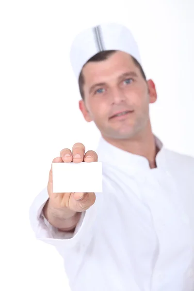 Chef holding up a blank business card — Stock Photo, Image