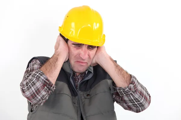 Trabalhador da construção que segura as mãos sobre os ouvidos — Fotografia de Stock