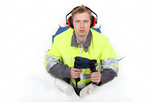 Travailleur portant une veste réfléchissante et perceuse — Photo