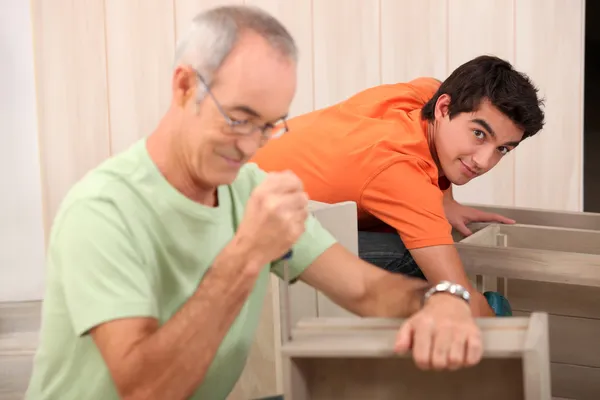 Großvater hilft Enkel bei den Möbeln — Stockfoto