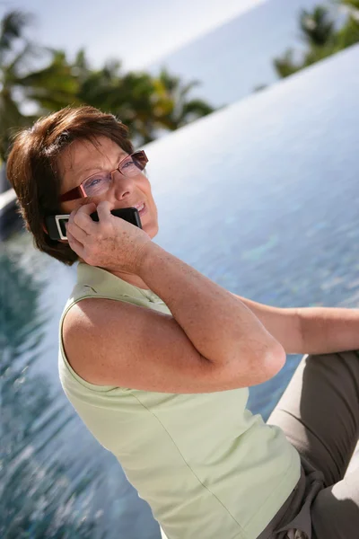 Vrouw praten over haar telefoon door het meer — Stockfoto