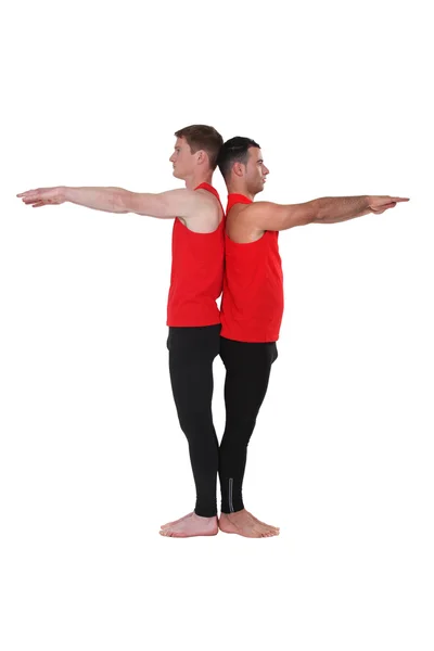 Manliga gymnaster rygg mot rygg — Stockfoto