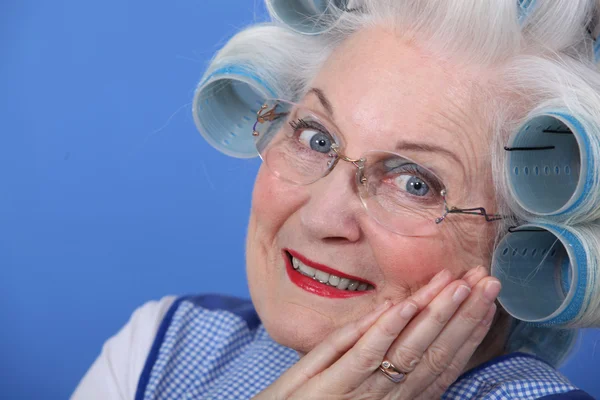 Ηλικιωμένης χρησιμοποιώντας μαλλιά οδοστρωτήρες — Φωτογραφία Αρχείου