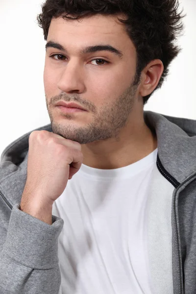 Mladý muž s rukou na bradě — Stock fotografie