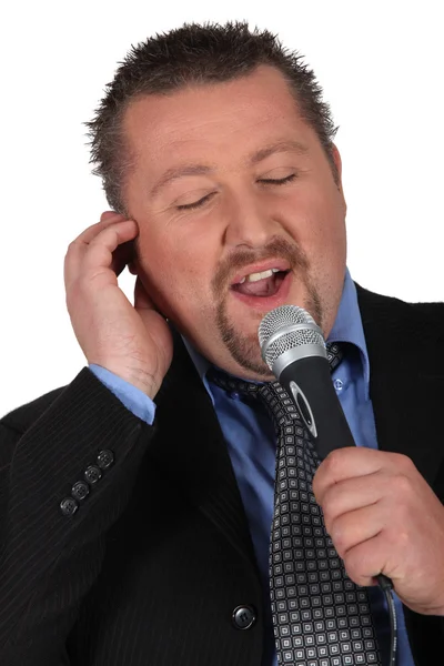 Empresário cantando em um microfone — Fotografia de Stock