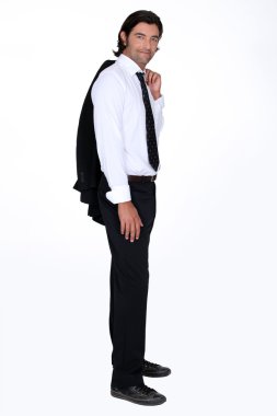 Relaxed man in a suit, holding his jacket over his shoulder clipart