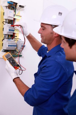 Electrician measuring current clipart