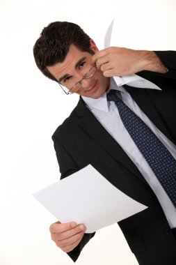 Intelligent businessman reading a document clipart