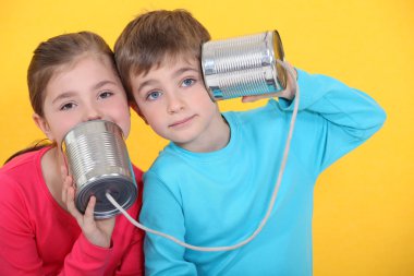 Children playing with tin cans clipart