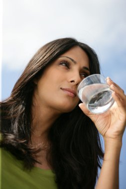 Thirsty woman drinking glass of water clipart