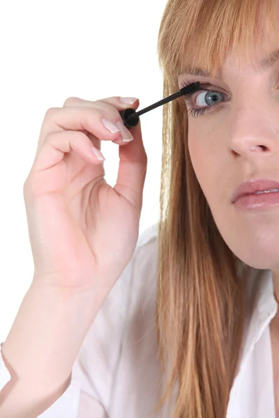 Kvinna som applicerar mascara på ögonfransarna — Stockfoto