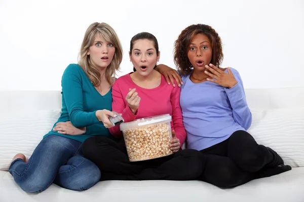 Tři ženy jíst popcorn, při sledování filmu — Stock fotografie