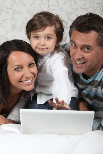Familie legt mit Laptop auf — Stockfoto