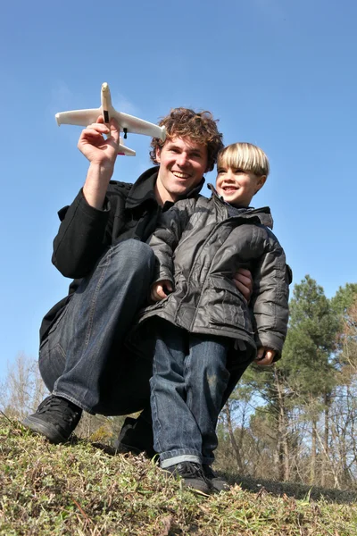 Отец и сын собираются запустить игрушечный самолет — стоковое фото