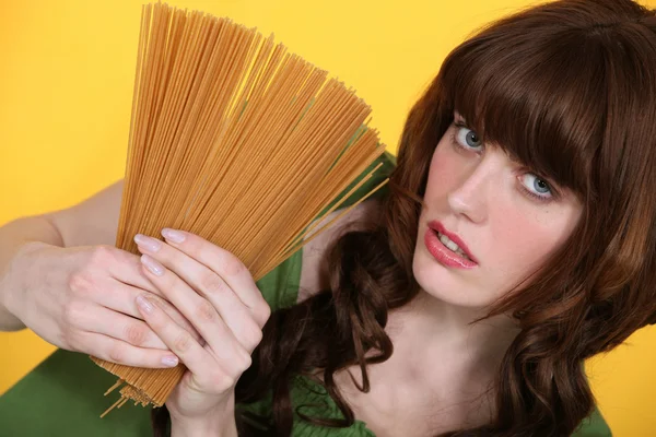 Vrouw met ongekookte spaghetti — Stockfoto