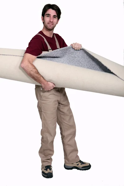 Man carrying rolled carpet — Stock Photo, Image